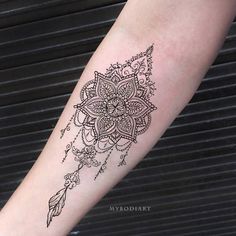 a woman's arm with a tattoo on it that has an intricate flower design