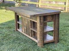 a wooden table sitting on top of a lush green field