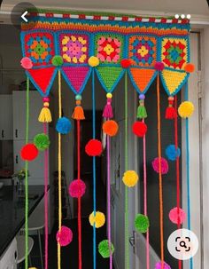 colorful crocheted decorations hanging from the ceiling with pom - poms and tassels