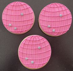 three decorated cookies sitting on top of a black table next to each other with white stars