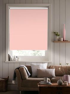 a living room with pink shades on the window