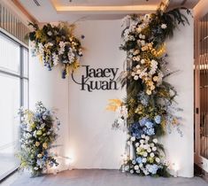 flowers are arranged on the wall in front of an open window and sign that says jasey huan