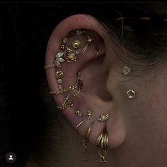 a woman with ear piercings on her ears and behind the ear is an assortment of jewelry