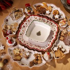 a table topped with plates and bowls filled with christmas cookies on top of each other