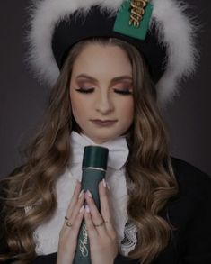 a woman with long hair wearing a green hat and holding a pipe in her hands