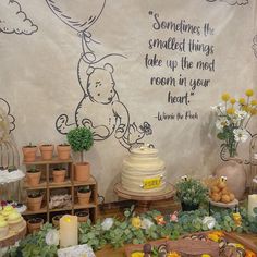 winnie the pooh themed birthday party with cake and flowers on display in front of wall