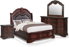 a bedroom with a bed, dresser and mirror on it's side table in front of the bed