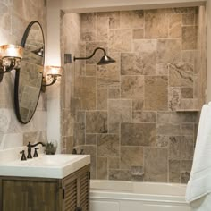 a bathroom with a sink, mirror and bathtub next to a wall mounted shower head