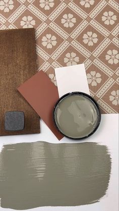 some brown and white paint sitting on top of a table next to a wall paper