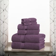 a stack of purple towels sitting on top of a wooden table