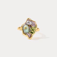 Elevate your jewelry collection with the enchanting allure of our Purple Pearl Tulip Flower Ring. This exquisite piece captures the delicate beauty of nature with its intricately crafted tulip flower design, accentuated by lustrous pearls set against a backdrop of rich, deep purple enamel. Crafted from 18K gold-plated brass, this ring exudes luxury and sophistication, making it a timeless accessory that adds a touch of elegance to any ensemble. Its unique design and vibrant color palette make it Nature-inspired Gold Flower Ring With Birth Flower, Nature-inspired Gold Birth Flower Ring, Delicate Gold Flower Ring With Gemstone, Gold Flower Rings For Jewelry Making, Nature-inspired Yellow Gold Flower Ring For Gift, Nature-inspired Yellow Gold Flower Ring As Gift, Nature-inspired Yellow Gold Flower Ring Gift, Nature-inspired Yellow Gold Flower Ring, Elegant Gold Enamel Flower Ring