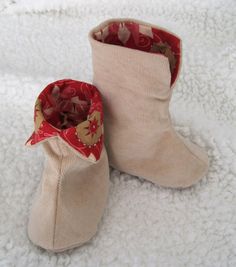 two pairs of baby booties sitting on top of a white carpeted floor next to each other