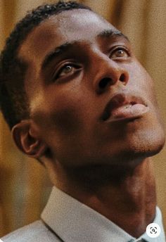 a close up of a person wearing a suit and tie with his head tilted to the side