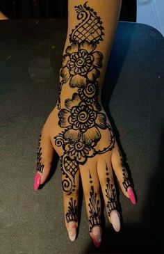 a woman's hand with henna tattoos on it