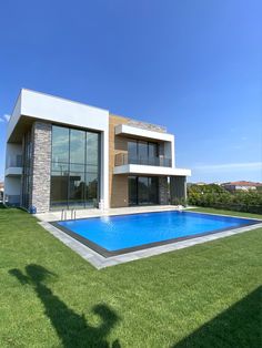 a house with a swimming pool in the front yard and grass on the lawn area