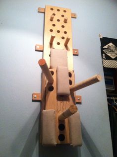 a wall mounted wooden object with holes in the middle and two pieces of wood attached to it