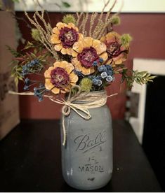 a mason jar filled with flowers on top of a table