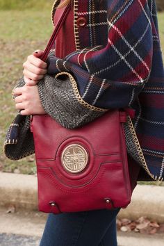 a woman carrying a red handbag on her shoulder