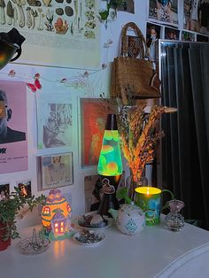 a table topped with vases filled with flowers and candles next to pictures on the wall