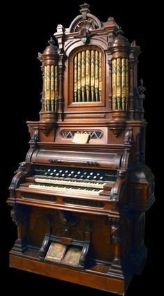 an old pipe organ sitting in front of a black background