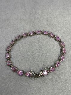 This is a beautiful pink CZ sterling silver bracelet. This bracelet features 20 pear cut pink CZs with each of them measuring 7x5 MM. The pink CZ show a strong fire and they're very transparent as they look like fine pink sapphires. The bracelet is approximately 8.5 inches in length. This bracelet is stamped 925 as well. This item is new and unworn. Silver And Pink Jewelry, Silver Cubic Zirconia Diamond Bracelet Pear-shaped, Formal Pink Gemstone Tennis Bracelet, Silver Pear-shaped Bracelets For Anniversary, Silver Pear-shaped Anniversary Bracelets, Pink Crystal Bracelet With Stones As Gift, Formal Pink Diamond Bracelet With 17 Jewels, Formal Pink Bracelets In Fine Jewelry Style, Pink Stone Jewelry For Anniversary