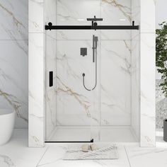 a white bathroom with marble walls and floor