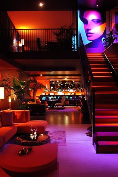 A modern hotel lounge with plush seating and ambient lighting, leading to a vibrant, neon-lit bar in the background. Lake Tahoe Hotels, Amalfi Coast Hotels, Sicily Hotels, Oregon Hotels, Myrtle Beach Hotels, Madrid Hotels, Lake Hotel, Seaside Florida