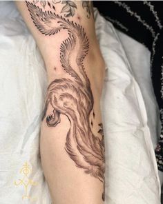 a woman's leg with a tattoo on it and a bird in the middle