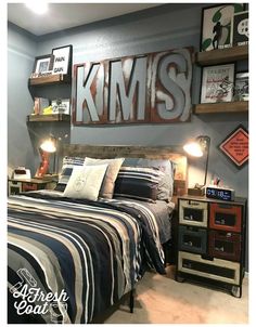 a bedroom decorated in blue and gray with pictures on the wall above the headboard