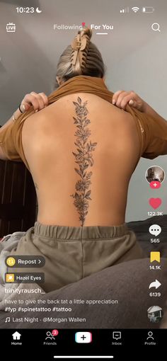 the back of a woman's body with tattoos on her upper and lower back