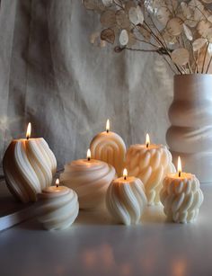 some white candles sitting next to each other on a table