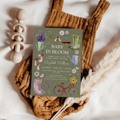 a baby in bloom book sitting on top of a bed next to an animal toy