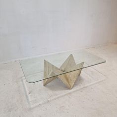 a glass and metal coffee table sitting on top of a white floor