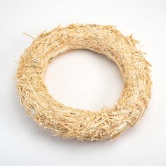 a round wreath made out of straw on a white background