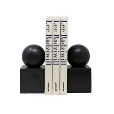 two bookends with black balls sitting on top of each other in front of a white background