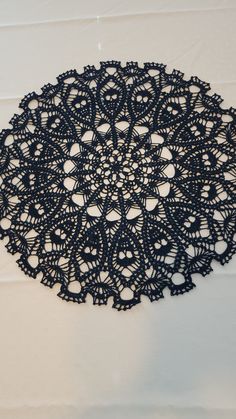 an intricate black doily on a white wall