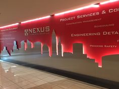 a large red sign is on the wall next to a white tiled floor in an office building