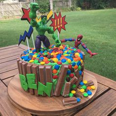 a birthday cake decorated with the hulk and spider - man characters on top of it