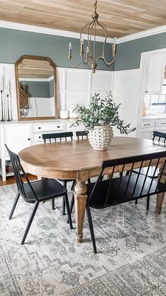 a dining room table with four chairs and a potted plant on top of it