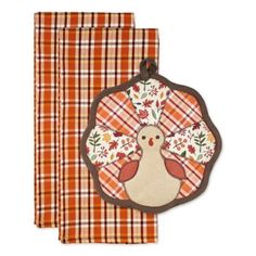 two napkins with an embroidered turkey on the front and plaid pattern in the back