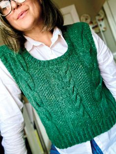 a woman wearing glasses and a green sweater