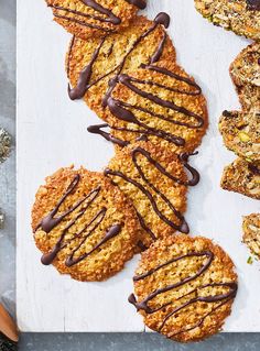 cookies with chocolate drizzled on them sitting on top of a cutting board