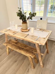 a wooden table with two benches next to it and a potted plant on top