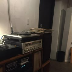 there is a record player and turntables on the shelf next to each other