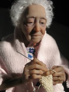 an elderly woman knitting with her hands