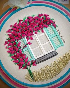 a embroidery project with pink flowers and green shutters