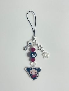 a key chain with an animal charm hanging from it's side on a white surface