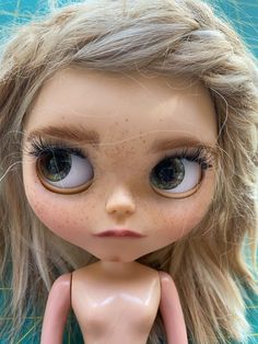 a doll with long blonde hair and big eyes