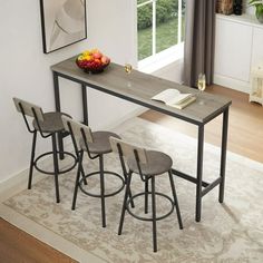 a dining table with four stools and a bowl of fruit on the counter top