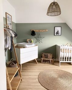 a baby's room with green walls and white furniture